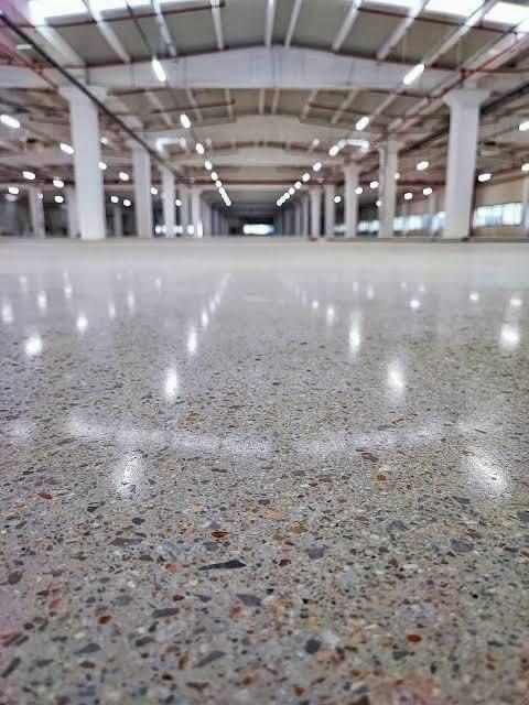 Geniş endüstriyel tesiste agregası görünen parlatılmış beton zemin