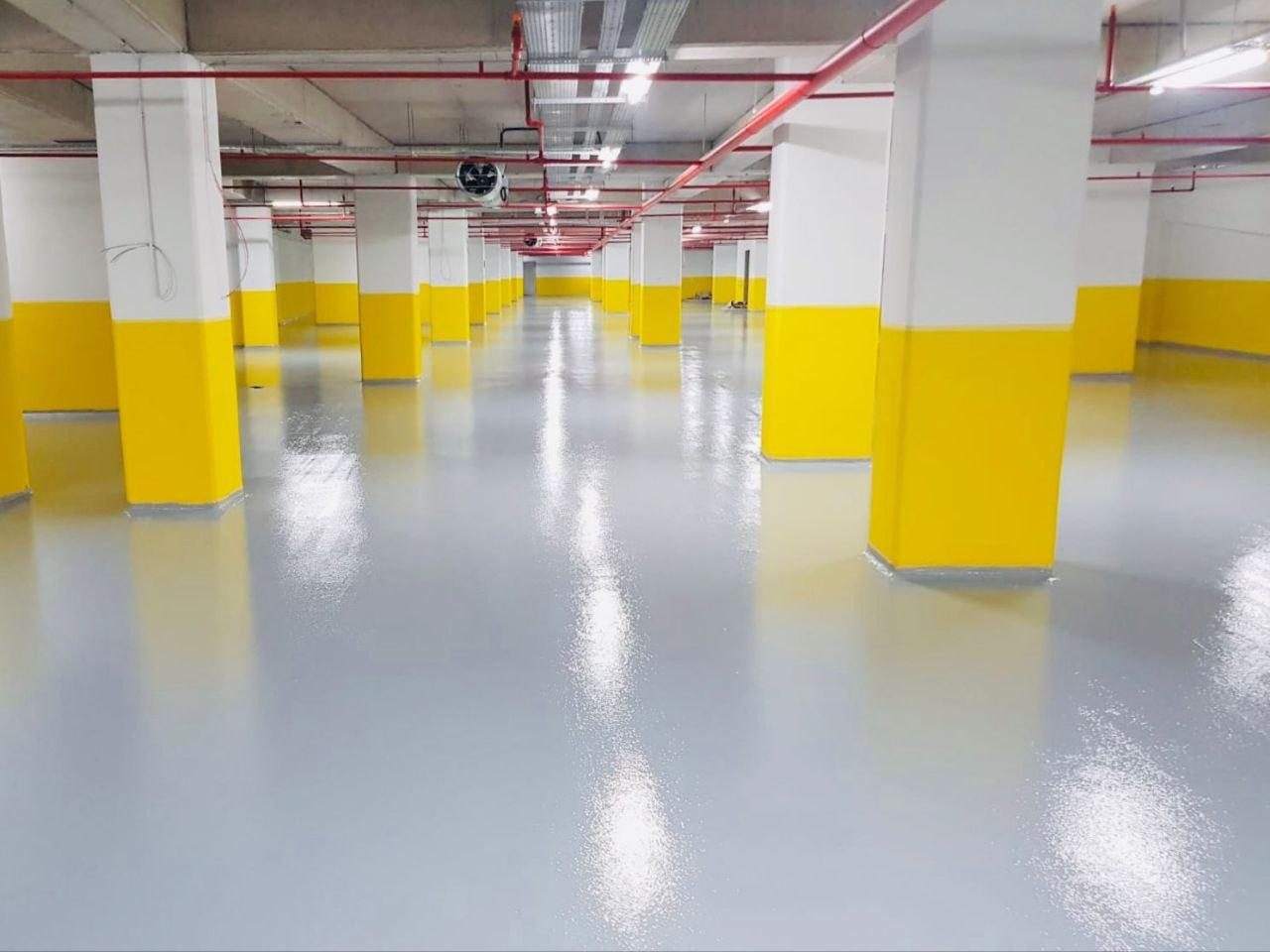 Sarı boyalı kolonlu otoparkta gri epoksi zemin kaplama